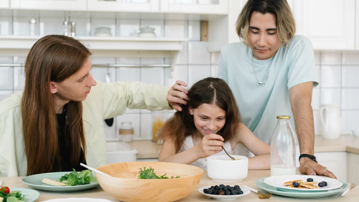 A joyful family moment in the kitchen as parents and daughter share a healthy breakfast together.